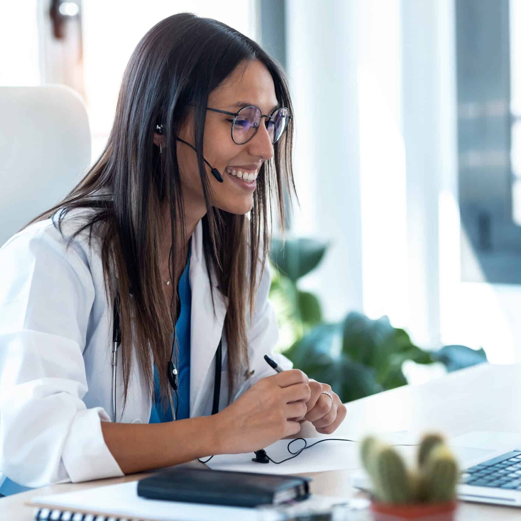 Shot of female doctor talking with colleagues through a video call with a laptop in the consultation.